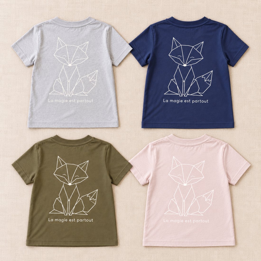 Les quatre T-shirts enfants : Gris Souris, Bleu Navy, Kaki et Rose Clair, avec le Grand Renard et « La magie est partout » au dos